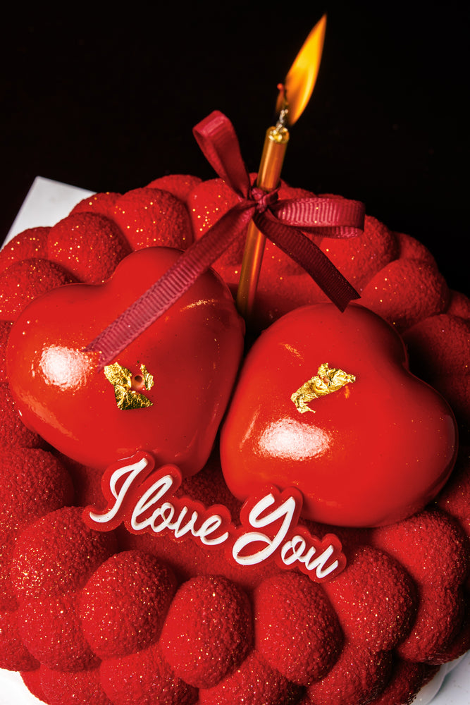 Gateau Gourmet Cafe red heart-shaped cake with I love you dessert decoration and lit candle