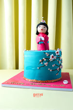 Gateau Gourmet Cafe cake featuring Japanese doll cake design with blue frosting and floral decorations