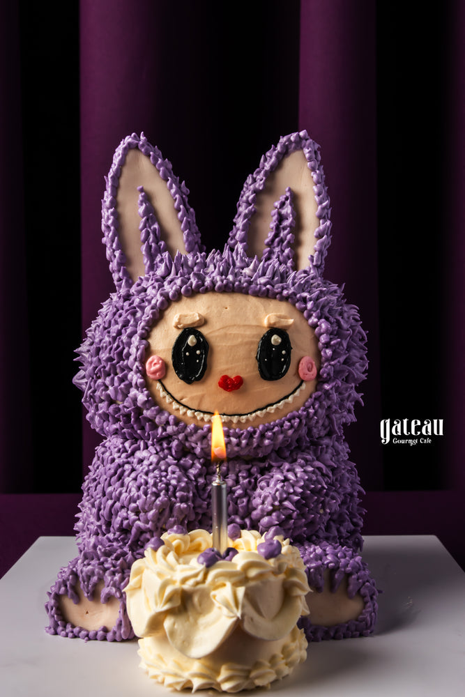 Labubu character cake from Gateau Gourmet Cafe with purple frosting and candle for celebrations