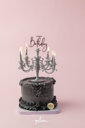 Gateau Gourmet Cafe Lumiere cake for special occasions with dark frosting and decorative candle holder