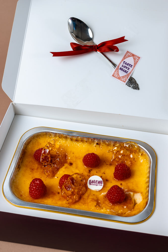 Lunch box creme brulee from Gateau Gourmet Cafe topped with fresh raspberries and a decorative spoon