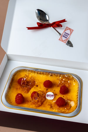 Lunch box creme brulee from Gateau Gourmet Cafe topped with fresh raspberries and a decorative spoon