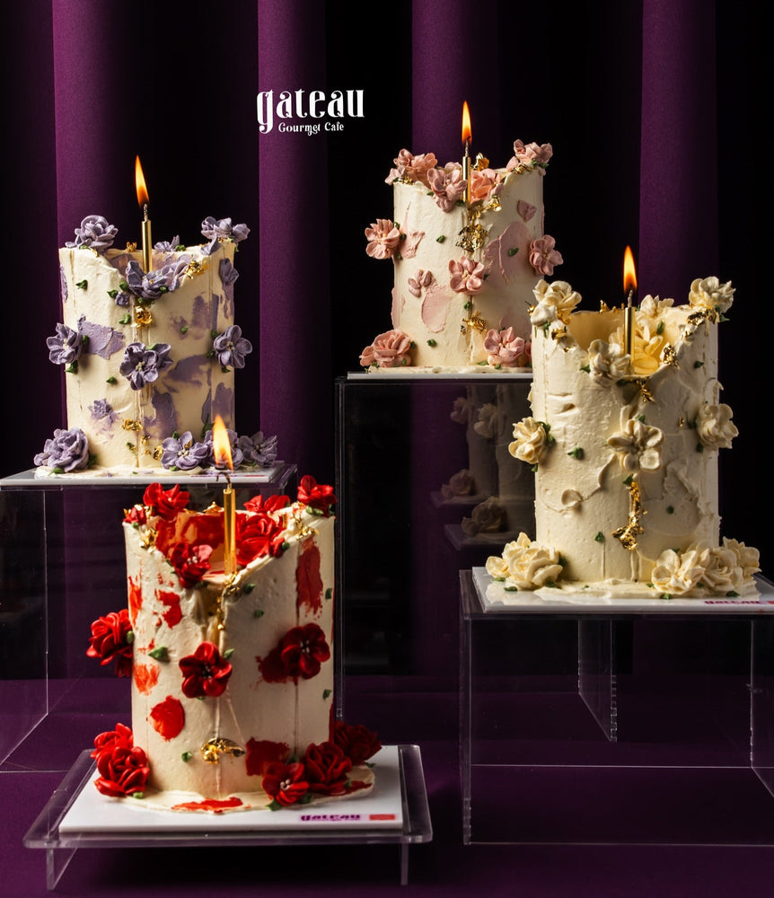 Luxury candlelight cake by Gateau Gourmet Cafe decorated with colorful floral designs and lit candles