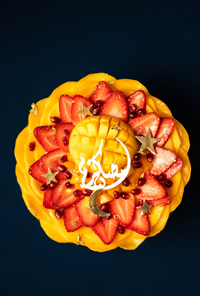 Mango fruit bowl dessert topped with fresh strawberries and pomegranate at Gateau Gourmet Cafe