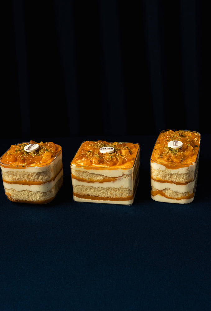 Three layered Mango Fruit Treats topped with mango slices and pistachios from Gateau Gourmet Cafe