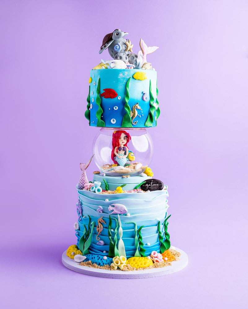Colorful mermaid birthday cake with ocean theme, featuring Ariel, sea creatures, and vibrant decorations