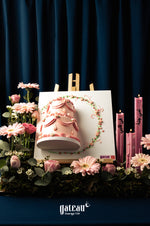 Mother's Day cake with pink floral decoration displayed with pink flowers and candles at Gateau Gourmet Cafe