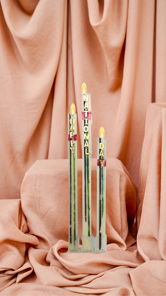 Three colorful candles spelling National Day candle for festive celebrations and parties