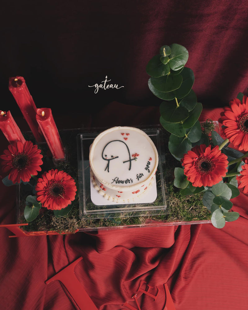 Order Flork cake online from Gateau Gourmet Cafe decorated with red flowers and greenery on a red fabric background