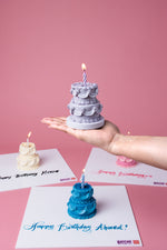 Order gourmet birthday cake with colorful mini tiered cakes in purple, blue, and white for celebrations