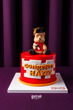 Personalized grad cake with name featuring a red base and a bear topper wearing a graduation cap
