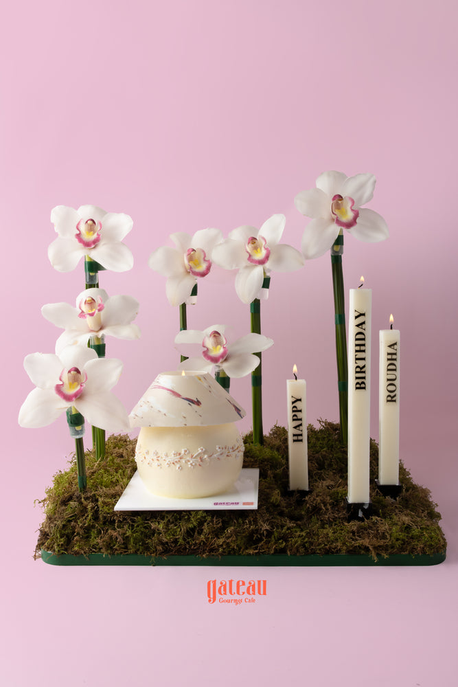 Elegant phalaenopsis flower cake arrangement with candles and moss for birthday celebrations