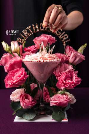 Pink princess birthday cake by Gateau Gourmet Cafe decorated with a crown and surrounded by pink roses