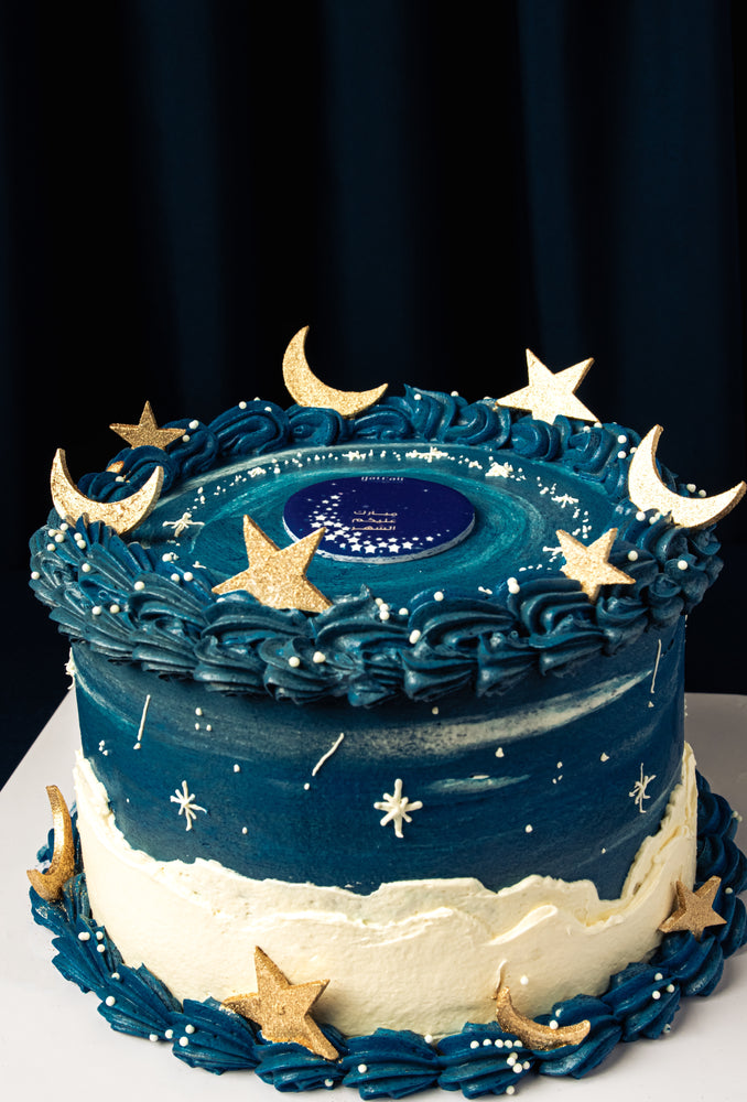 Ramadan celebration cake by Gateau Gourmet Cafe with blue and white frosting decorated with golden stars and crescent moons