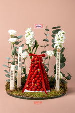 Raspberry mountain centerpiece cake with decorative flowers and birthday candles from Gateau Gourmet Cafe