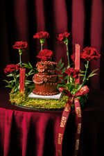 Gateau Gourmet Cafe red mini classic cake decorated with red flowers and candles on a green moss base
