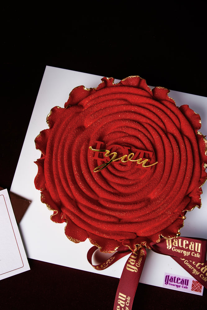 Red Rose Mousse Cake With Candle elegantly decorated with a gold ribbon at Gateau Gourmet Cafe