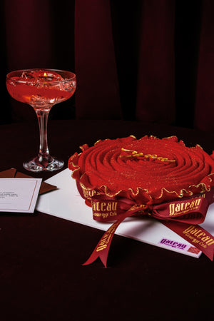 Red Rose Mousse Cake With Candle elegantly presented with a sparkling drink and colorful decorations