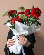 Special Red Chrysanthemum Flower Bouquet wrapped in white paper, held by a person with stylish nails