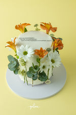 Summer colors flowery cake adorned with vibrant flowers, perfect for celebrations at Gateau Gourmet Cafe