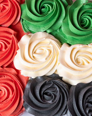 Colorful UAE Flag Day cupcakes with red, green, white, and black frosting swirls from Gateau Gourmet Cafe