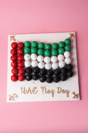 UAE Flag Day truffles arranged in flag colors on a decorative board from Gateau Gourmet Cafe