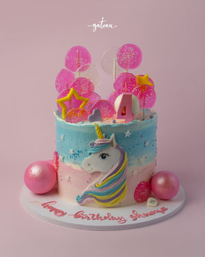 Colorful unicorn birthday cake with pink and blue layers, decorated with balloons and a unicorn topper