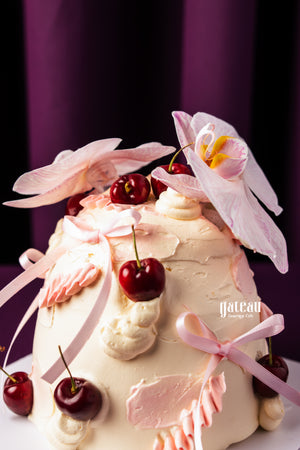 Unique birthday cake with cherries decorated with pink flowers and ribbons from Gateau Gourmet Cafe