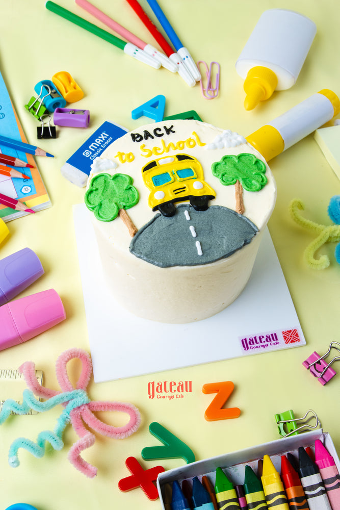 Yellow school bus birthday cake decorated with trees and road for a fun back-to-school celebration